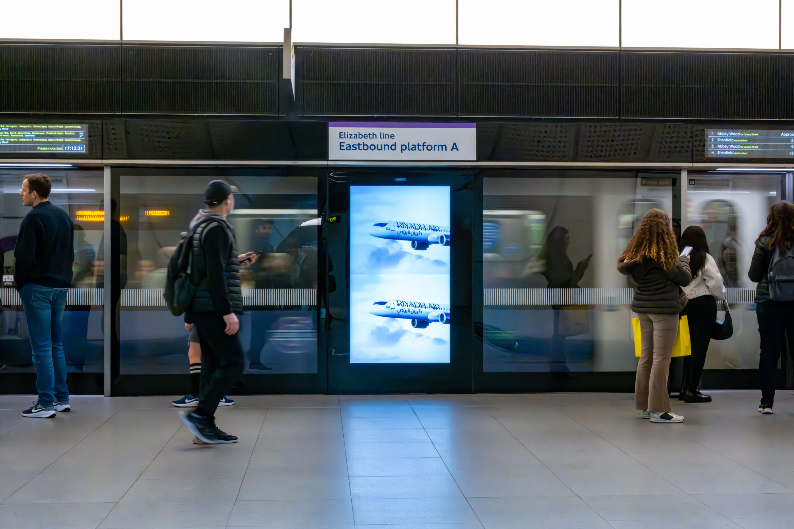 Example of OOH advertisement being viewed by someone holding a mobile phone.