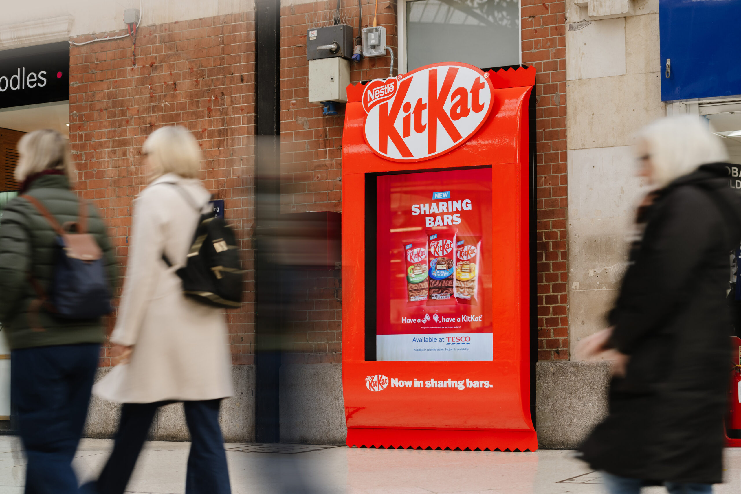 An example of a special build with a digital screen in a train station, showcasing a wrapped kitkat.